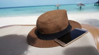 Hasır şapka Maldivler okyanus denizde akıllı telefon. Tatil relax arka plan