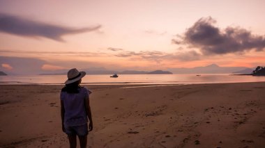 Asyalı kadın siluet gündoğumu okyanus pembe ve turuncu gökyüzü