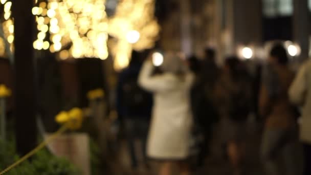 Weihnachtsbeleuchtung in Tokio, Japan verschwimmen lassen. Menschen, die spazieren gehen, sich treffen, feiern — Stockvideo