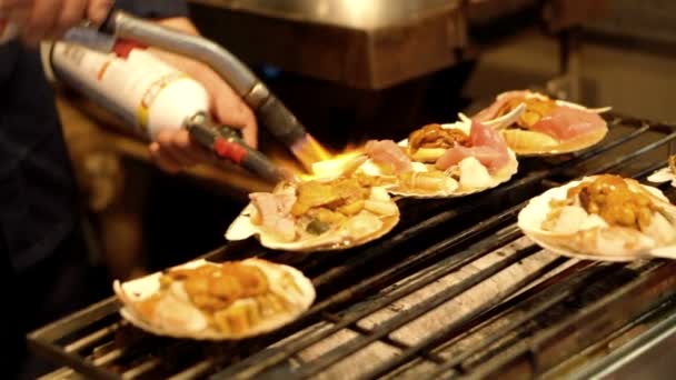 Griglia di frutti di mare assortiti in guscio al mercato Tsukiji, Giappone. Chef con torcia bruciata — Video Stock