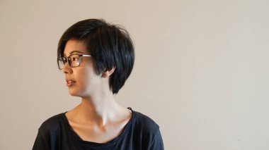 Kısa saçlı ve gözlüklü renk arka plan üzerinde ile Asyalı kadın