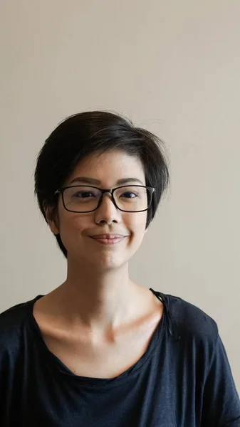 Asian woman  with short hair and glasses on color background — Stock Photo, Image