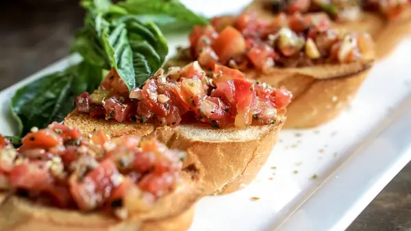 Bruschetta předkrm v italské restauraci. Letní rajčata aktualizovat potravin — Stock fotografie
