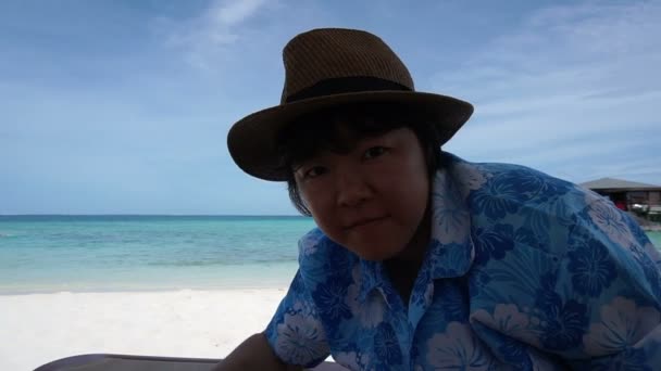 Asian tourist woman inviting people to beach ocean paradise through cam POV — Stock Video