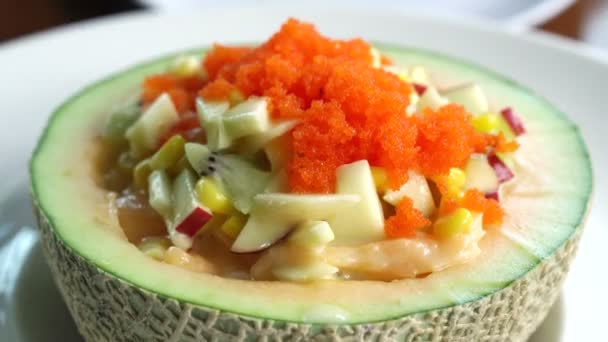 Fruit salad in cantaloupe bowl. Scooped water melon, melon, salad dressing and fish eggs on top healthy food — Stock Video