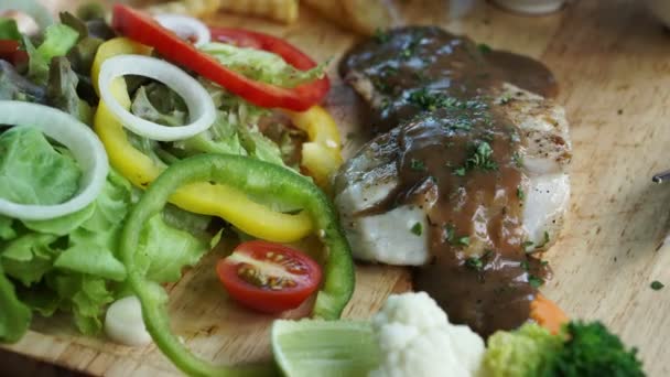 Filete de pescado con salsa de pimienta en la parte superior con saland y papas fritas guarniciones — Vídeo de stock