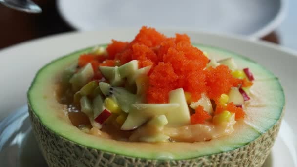 Obstsalat in der Cantaloupe-Schüssel. geschöpfte Wassermelone, Melone, Salatdressing und Fischeier obendrauf gesunde Kost — Stockvideo