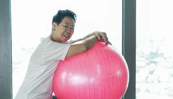 Asiatico anziano sano vecchio donna esercizio con rosa ginnastica palla — Foto Stock