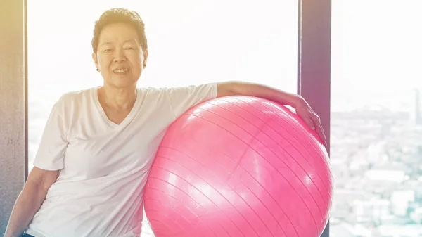 亚洲高级老健康女人锻炼与粉红色的体操球 — 图库照片