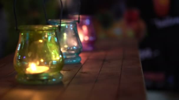 Lâmpadas coloridas de vidro de vela à noite 4K — Vídeo de Stock