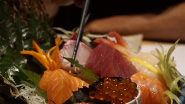Palillos comiendo sashimi fresco crudo surtido. Comida japonesa cocina tradicional — Vídeos de Stock