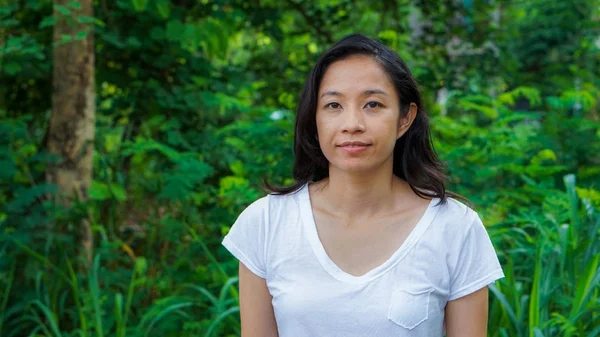 Asian woman long hair with facial epression green nature backgro — Stock Photo, Image