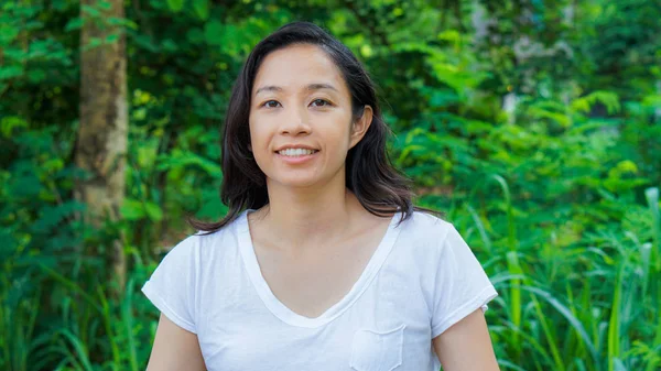 De lange haren Aziatische vrouw met gezichts epression groene natuur achtergrond — Stockfoto
