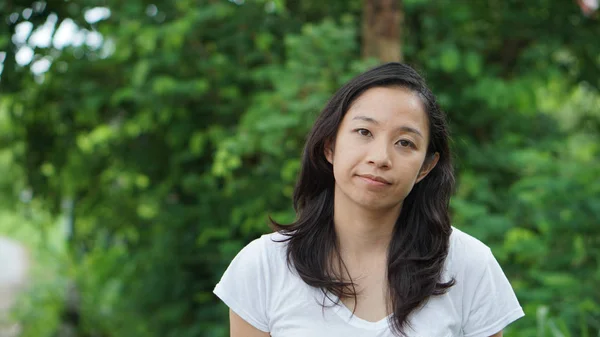 Asian woman long hair with facial epression green nature background — Stock Photo, Image