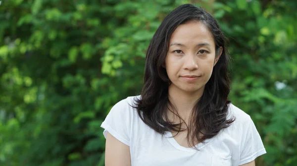 Asian woman long hair with facial epression green nature backgro — Stock Photo, Image