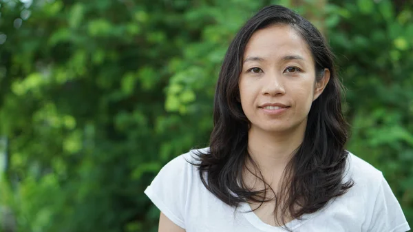 Asian woman long hair with facial epression green nature backgro — Stock Photo, Image