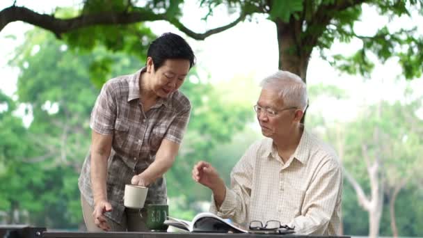 Asiático senior pareja bebiendo café en mañana hermosa parque — Vídeos de Stock