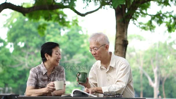 Asiático senior pareja bebiendo café en mañana hermosa parque — Vídeo de stock