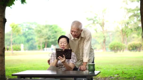 Asian senior laughing using pad for digital communicationiors — Stock Video