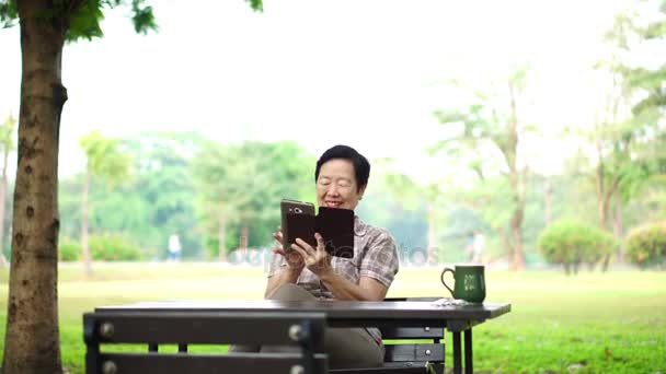 Asya kıdemli için dijital communicationiors defterini kullanma gülüyor — Stok video