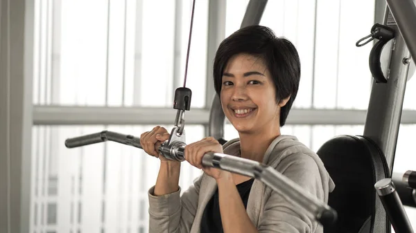 Asya kısa saçlı kadın fitness makine gülümsemek yüz eğitim — Stok fotoğraf