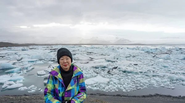 Азиатская старуха отправляется в лагуну ледников Джоколсарлон, Исландия — стоковое фото