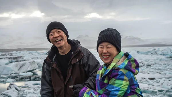 Asiático casal sênior diversão viagem na Islândia, majestoso glaciar lagoa — Fotografia de Stock