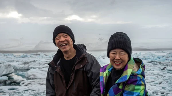 Ασιατισα Ζευγάρι ανώτερος διασκεδαστικό ταξίδι στην Ισλανδία, επιβλητικό παγετώνα λιμνοθάλασσα — Φωτογραφία Αρχείου