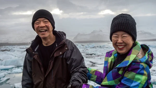 Asiático casal sênior diversão viagem na Islândia, majestoso glaciar lagoa — Fotografia de Stock