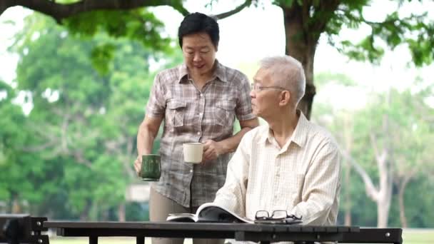 Asiatische Senioren Paar Lesen Buch Trinken Tee — Stockvideo