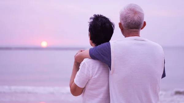 Asian senior couple dating at sunrise sea — Stock Photo, Image
