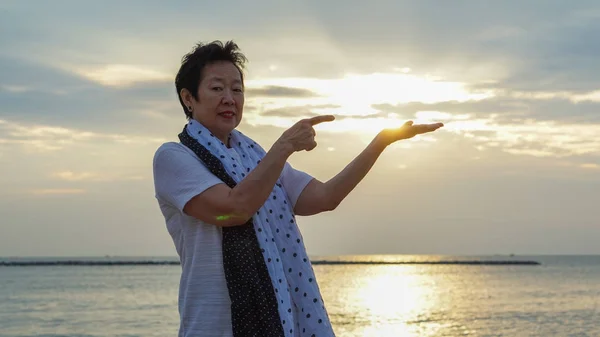 Asian senior woman with hand holding sun concept of success and future — Stock Photo, Image