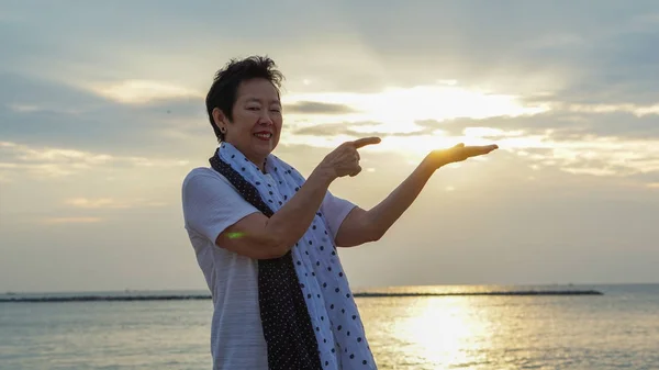 Asian senior woman with hand holding sun concept of success and future — Stock Photo, Image