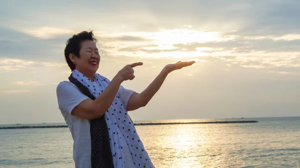 Asian kobieta senior z ręki trzymającej słońce koncepcja sukcesu i przyszłość — Zdjęcie stockowe