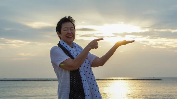 Asian senior woman with hand holding sun concept of success and future — Stock Photo, Image