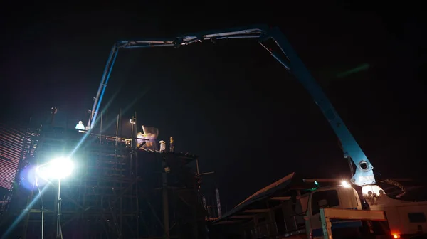 Construção caminhão guindaste trabalhando na estrutura à noite — Fotografia de Stock