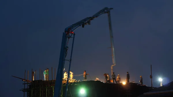 Camión grúa de construcción trabajando en la estructura por la noche — Foto de Stock