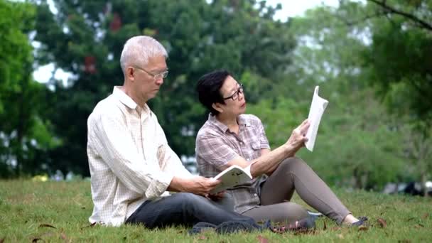 Aziatische Senior Paar Lezing Boeken Park Recreatie Outdoor Activiteit — Stockvideo