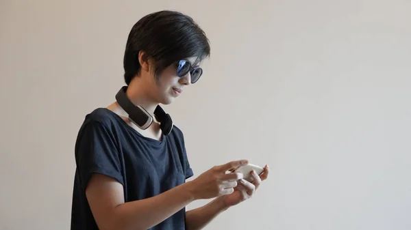 Asyalı kadın yaşam tarzı Kulaklık kullanırken Smartphone kullanarak bir — Stok fotoğraf