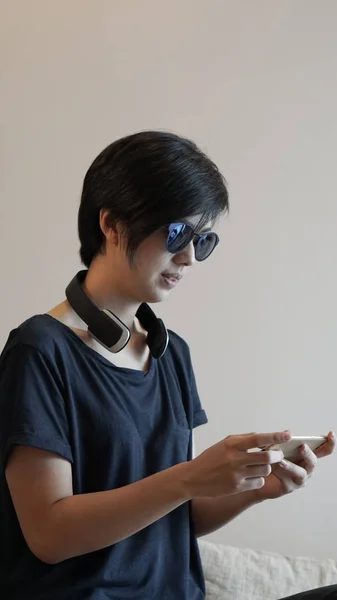 Stile di vita donna asiatica utilizzando smartphone durante l'utilizzo di cuffie un — Foto Stock