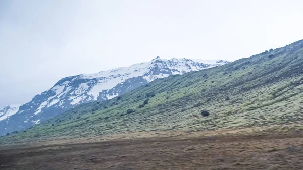 Islandia tiempo nieve y niebla mountaitn fondo, verde musgo fi — Foto de Stock