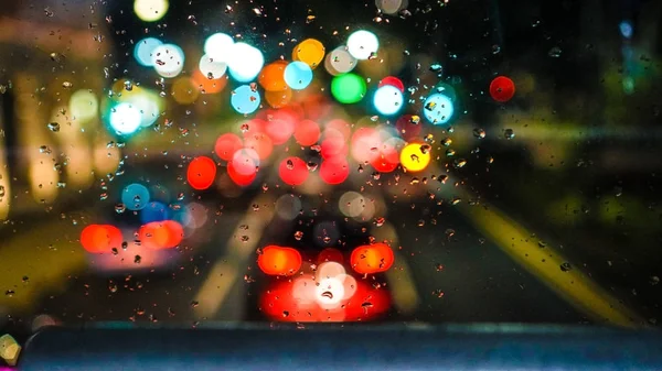 Blur cidade semáforo chuva cai na janela de ângulo alto — Fotografia de Stock