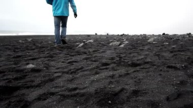 Turist adam keşfetmek İzlanda siyah plaj ağır çekim video