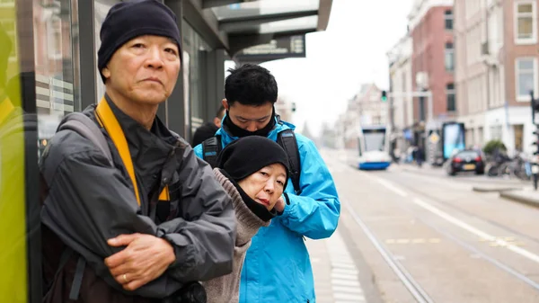 Famiglia asiatica in attesa di autobus alla fermata dell'autobus in Europa viaggio — Foto Stock