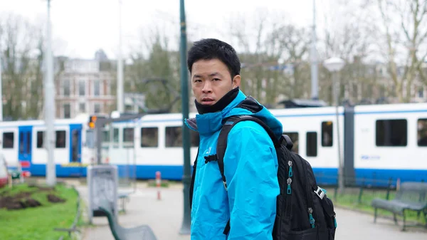 Asian man travel europa rucksack amsterdam, tram hintergrund — Stockfoto
