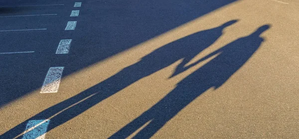 Pareja larga sombra cogida de la mano en el viaje por carretera — Foto de Stock