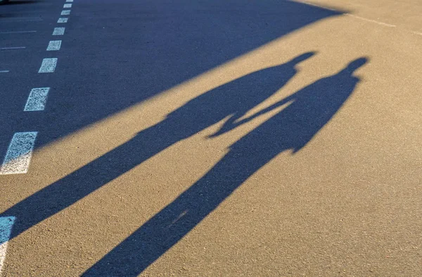 Couple long shadow holding hand on road trip Royalty Free Stock Images