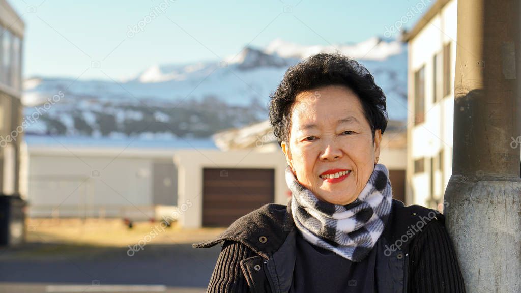 Asian senior woman portrait in Europe snow mountain village mori
