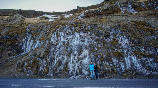 Family with frozen waterfall road trip scene in Iceland — Stock Photo, Image