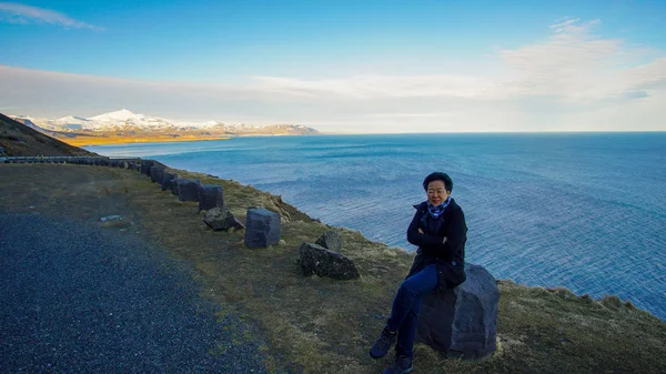 Asian senior woman travel on top of Iceland road mountain bay vi — Stock Photo, Image